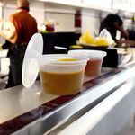 Close-up of leakproof lid on microwavable sauce pots, ensuring secure and mess-free food transport