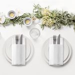 Disposable white airlaid napkin with cutlery pocket — ideal for professional restaurant table setups.