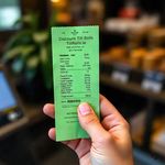 Image of a customer holding a green credit card receipt supplied by Discount Till Rolls Ireland